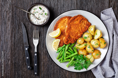 Fotografie German pork schnitzel with potato and green beans