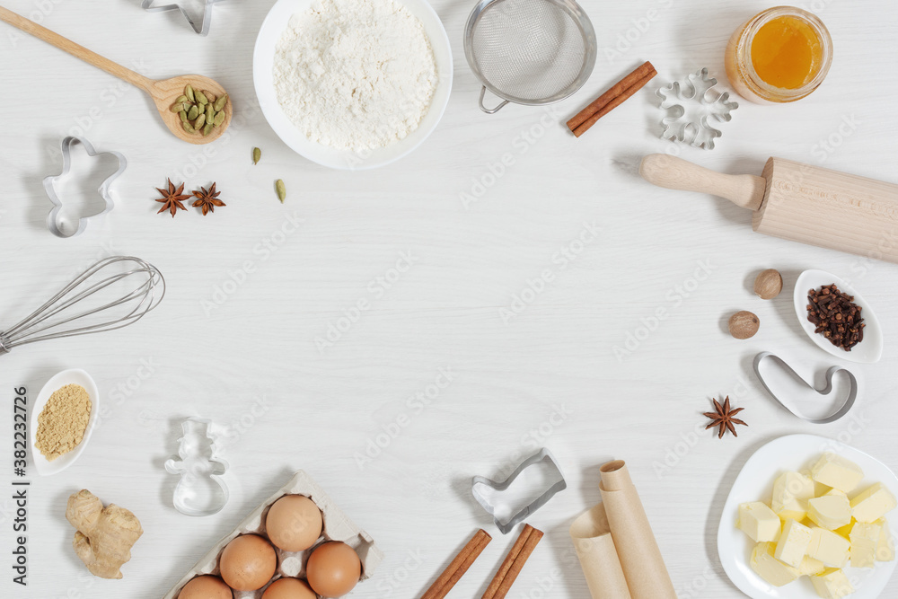 Ingredients for baking Christmas gingerbread cookies top view on white wooden background.