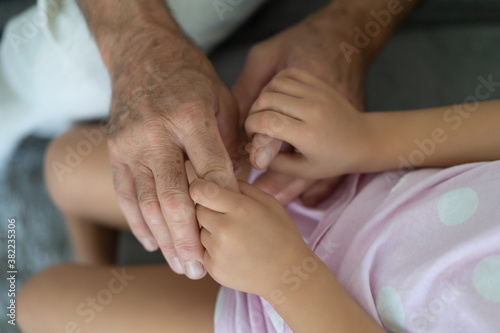 hands of a grandfather holding the hands of a girl