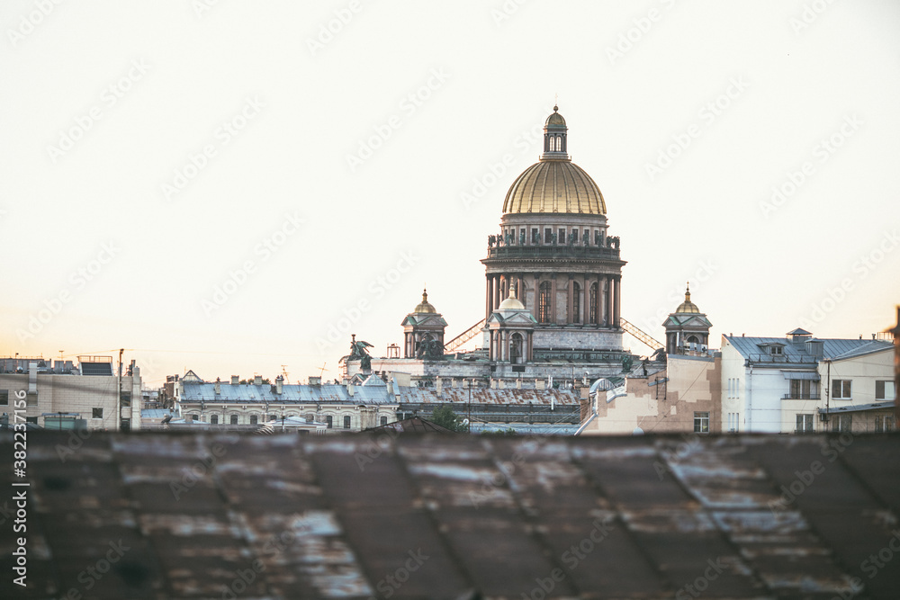 Sunset view at the Isaak Cathedral from the roof of Saint-petersburg city. Ancient roof of the city. Old historical city. Amazing sunset at the top of the city. Image with noise effect.