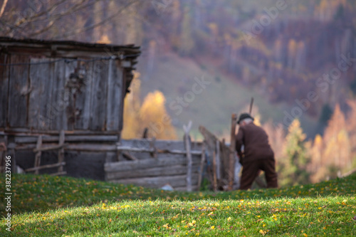 Fotografija Out of focus background with a villager old man working in his garden