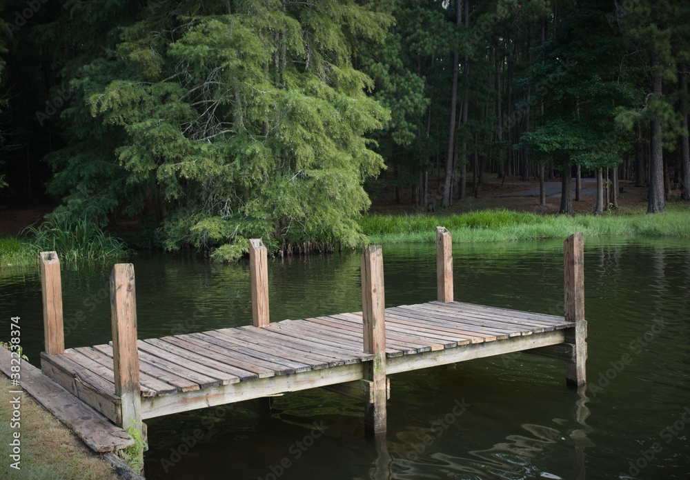 Wooden Pier on peaceful lake by a forest.
