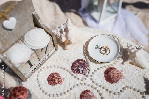 Fotografie Close up view of wedding rings in the white ceramic shell on the table with wedd