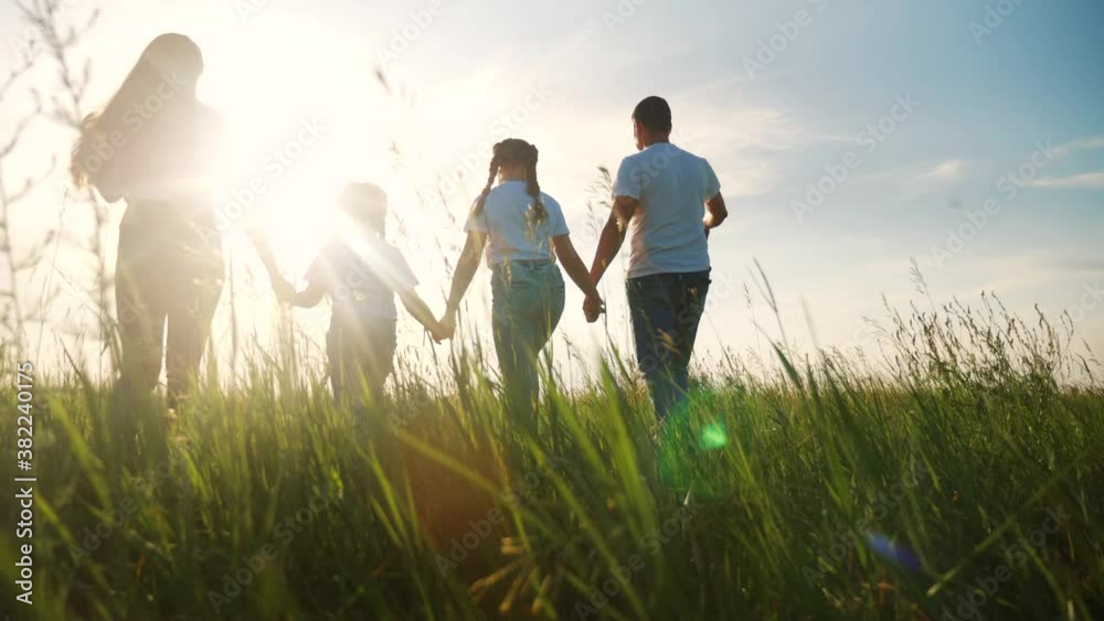 happy family walking together in the park silhouette. friendly family kid dream concept. happy family walking holding hands in the park on the grass at sunset. friendly family dream lifestyle together happy family walking together in the park silhouette. friendly family kid dream concept. happy family walking holding hands in the park on the grass at sunset. friendly family dream lifestyle together