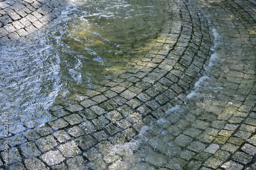 unusual texture background fragment of a stone-paved pool filled with water