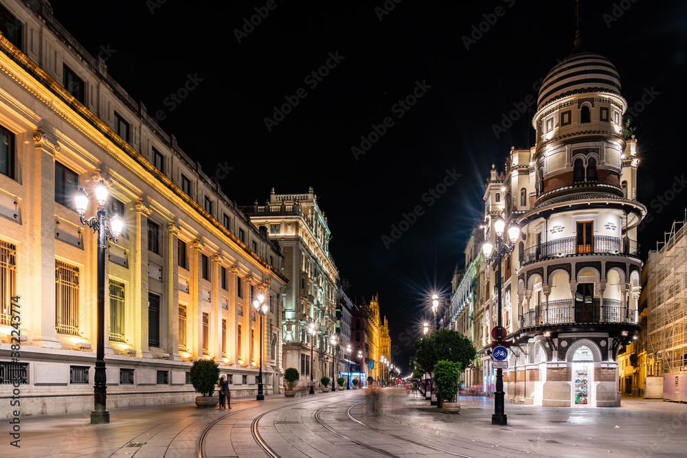 The lights of Seville's buildings at night looking down the Avenida de la Constitucion towards the Catedral de Sevilla, Seville, Andalusia, Spain The lights of Seville's buildings at night looking down the Avenida de la Constitucion towards the Catedral de Sevilla, Seville, Andalusia, Spain