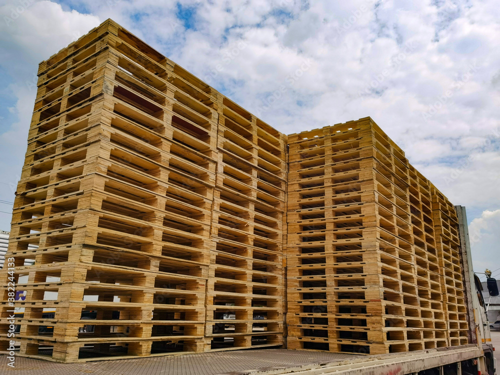 Worker driving forklift to loading wooden pallets from truck to warehouse cargo storage, shipment in logistics and transportation industrial, wood pallets stack, delivery service Worker driving forklift to loading wooden pallets from truck to warehouse cargo storage, shipment in logistics and transportation industrial, wood pallets stack, delivery service