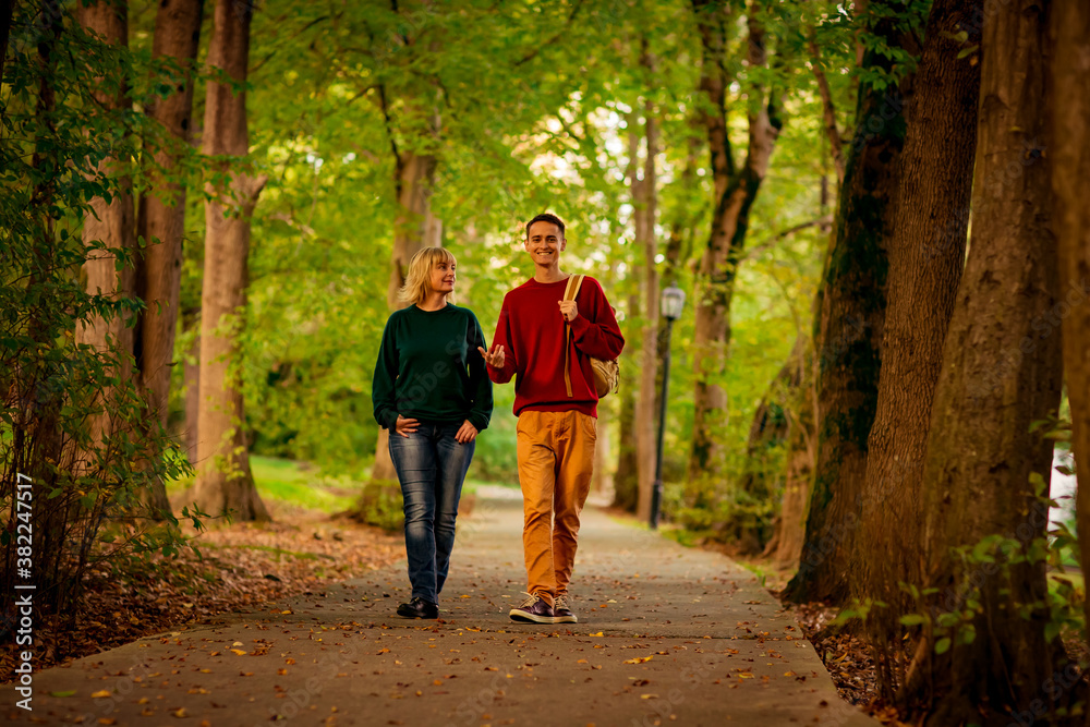 Beautiful woman,blonde,middle-aged,with a big son walking in the Park,a beautiful autumn day Beautiful woman,blonde,middle-aged,with a big son walking in the Park,a beautiful autumn day
