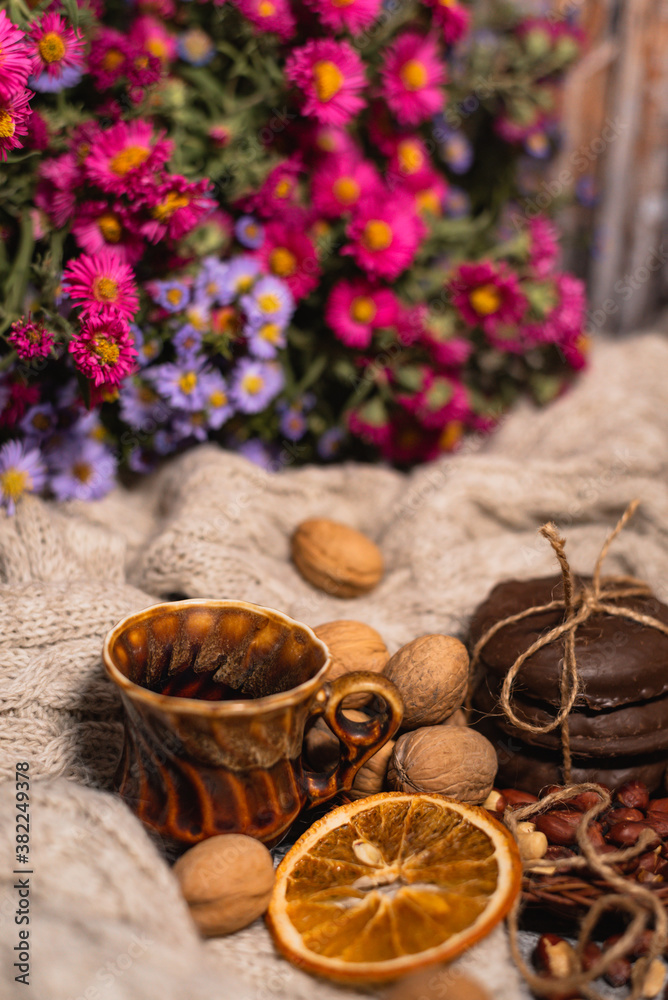 set for cozy autumn. cozy autumn. cup of tea, chocolate cookies, candle, cinnamon, anise, nuts on white knitted sweater. Hygge lifestyle set for cozy autumn. cozy autumn. cup of tea, chocolate cookies, candle, cinnamon, anise, nuts on white knitted sweater. Hygge lifestyle