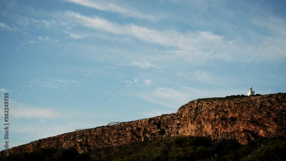 Time lapse of white clouds moving over spanish Costa Blanca coastline with lighthouse on cliff, Spain Alicante province, Santa Pola region. Time lapse of white clouds moving over spanish Costa Blanca coastline with lighthouse on cliff, Spain Alicante province, Santa Pola region.