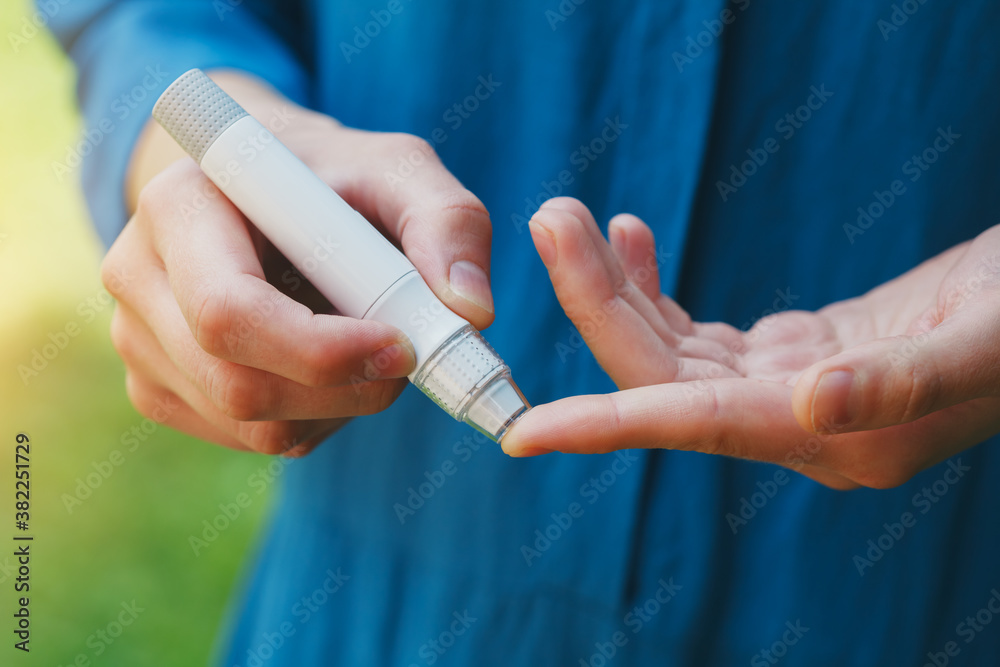 young woman hands using lancet on finger to check blood sugar level, diabetes concept, health care young woman hands using lancet on finger to check blood sugar level, diabetes concept, health care