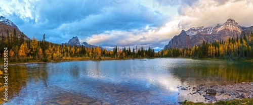 Wide Panoramic Landscape of Scenic Schaffer Lake with Autumn Colors on Larch Trees and Dramatic Stormy Sky Cloudscape near Lake O’Hara, Yoho National Park, Canadian Rocky Mountains photo