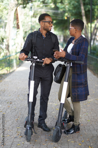 Happy business people talking. They are on electric scooters photo