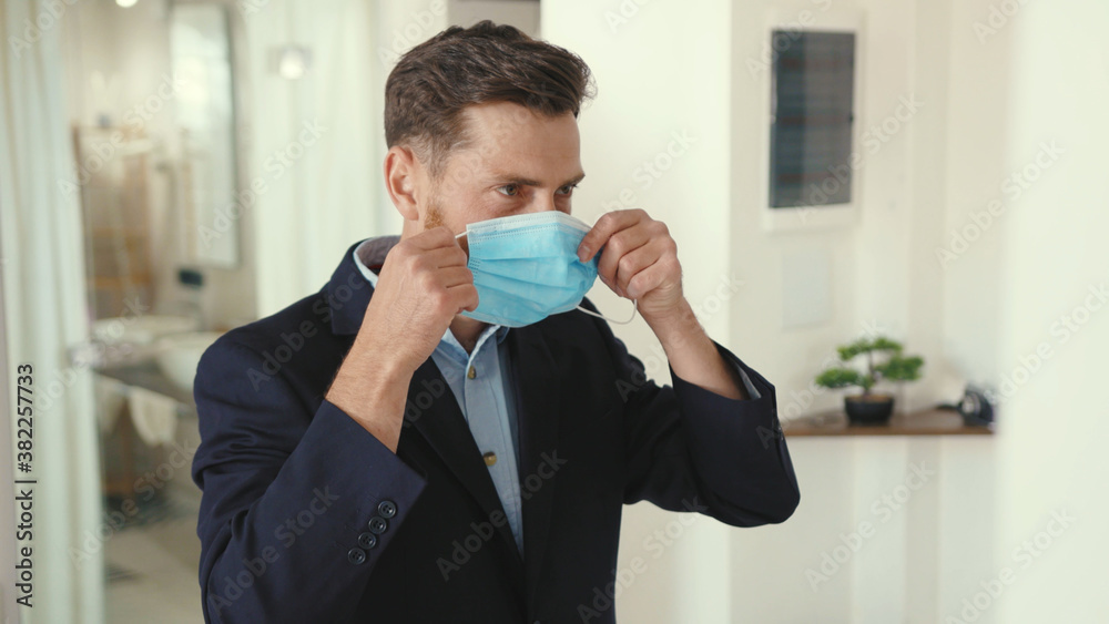 Attractive businessman getting ready with mask look at mirror and wearing suit jacket go work home safety professional protection apartment corona pandemic slow motion Attractive businessman getting ready with mask look at mirror and wearing suit jacket go work home safety professional protection apartment corona pandemic slow motion