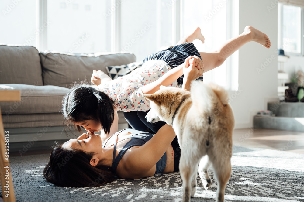 Asian young mom and daughter practicing yoga at home Asian young mom and daughter practicing yoga at home