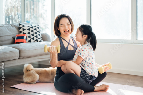 Asian young mom and daughter practicing yoga at home photo