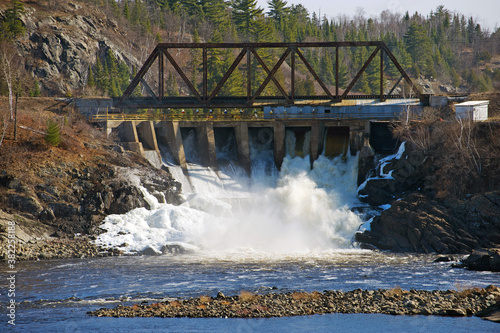 A view of the dam portion of a pulp and paper mill which uses water, energy and wood pulp to produce paper.