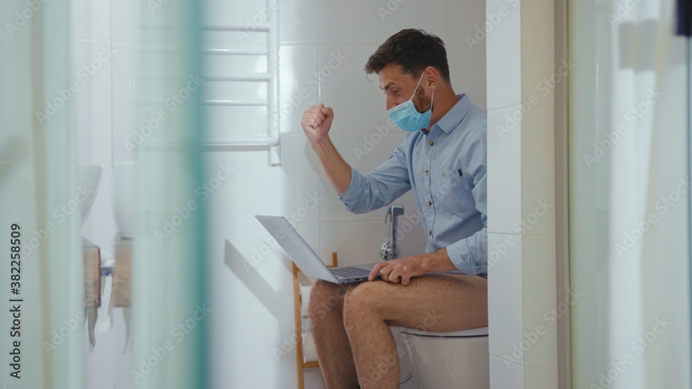 Happy businessman working on laptop wearing mask sit on the toilet at home restroom bearded funny wc isolation quarantine pandemic coronavirus covid-19 portrait close up slow motion Happy businessman working on laptop wearing mask sit on the toilet at home restroom bearded funny wc isolation quarantine pandemic coronavirus covid-19 portrait close up slow motion