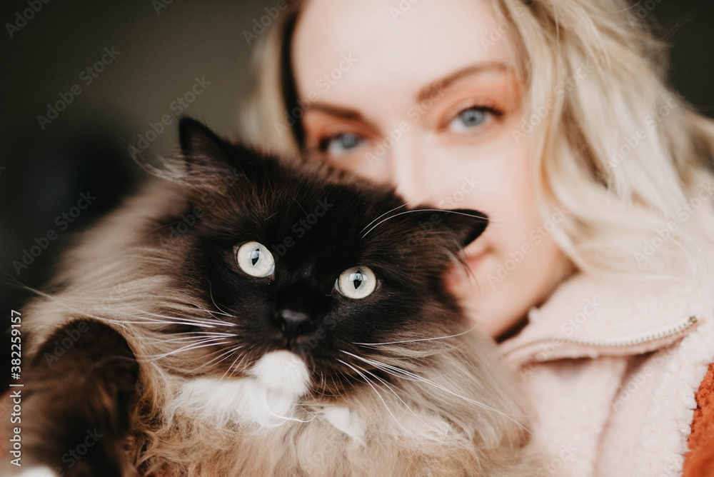 A woman posing for a picture with her cat A woman posing for a picture with her cat