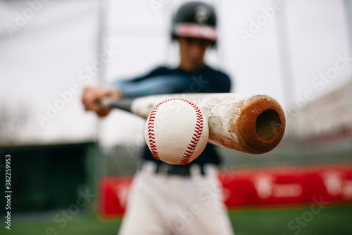 Batter hitting baseball ball with bat