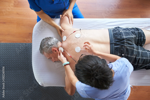 Physiotherapists giving a patient a muscle treatment photo