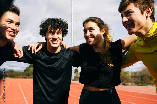 Teen athletes hugging each other