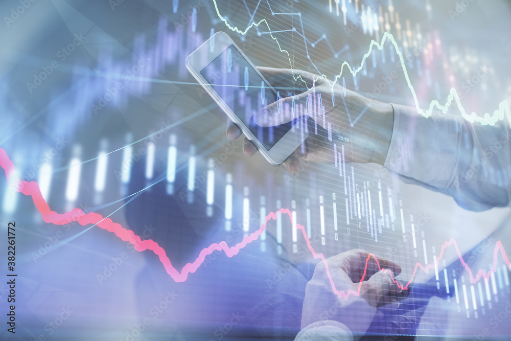 Double exposure of man's hands holding and using a digital device and forex graph drawing. Financial market concept. Double exposure of man's hands holding and using a digital device and forex graph drawing. Financial market concept.