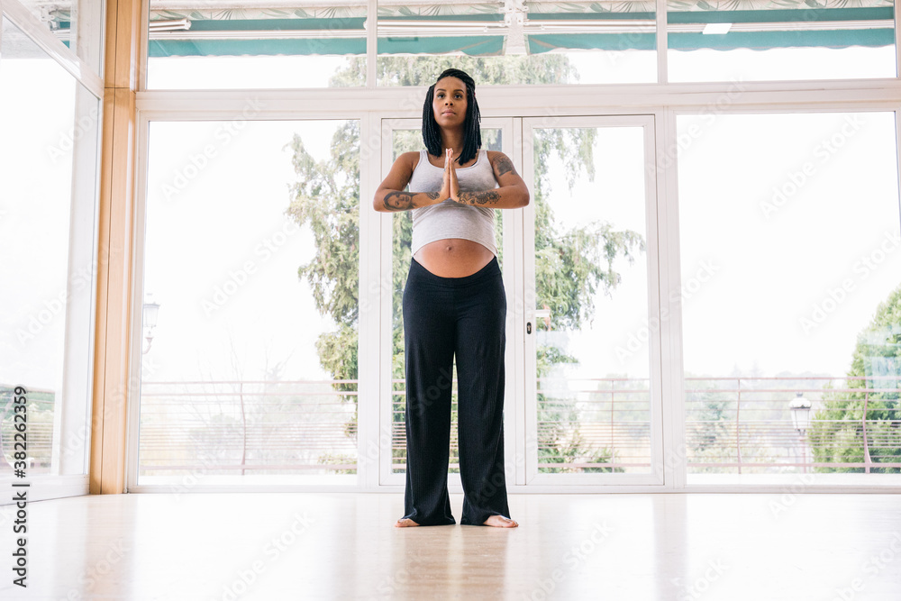 Cheerful black woman in expectancy practicing yoga Cheerful black woman in expectancy practicing yoga