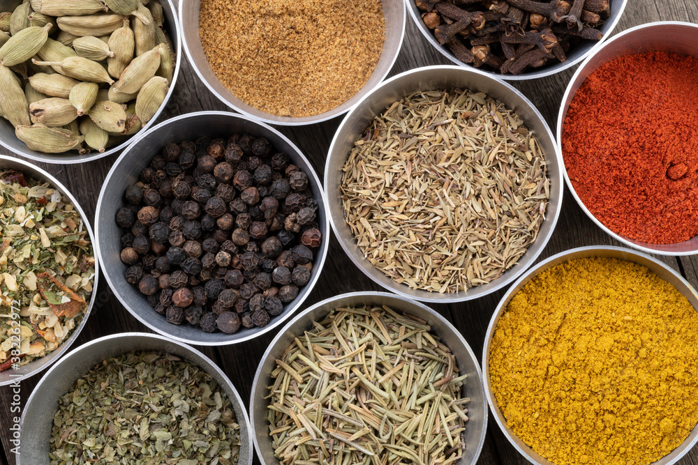 Seasonings on metallic bowls over wooden table