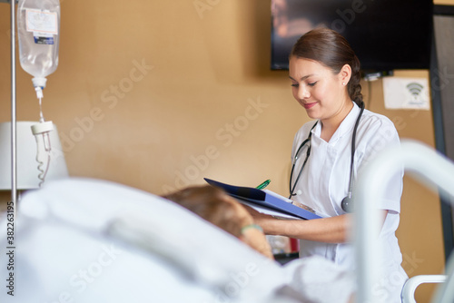Smiling practitioner caring for a woman in a hospital bed