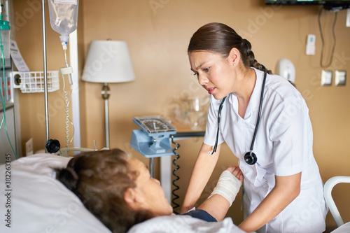 Medical professional giving encouragement to older woman in a hospital