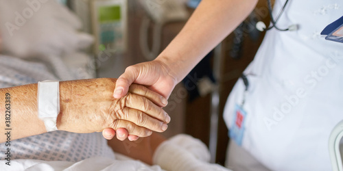 Nurse holding the hand of an older patient
