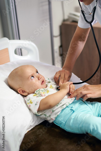 8 month year old baby having a checkup with a nurse photo