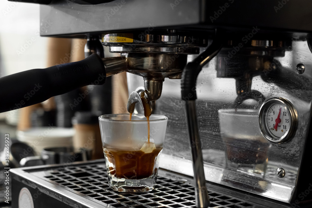 Espresso machine pouring shot into glass cup Espresso machine pouring shot into glass cup