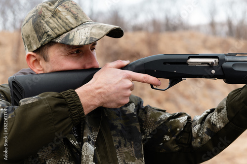 Adult man shooting rifle in nature