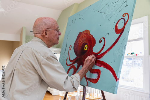 Contemplative Senior Man Painting in Home Artist Studio photo