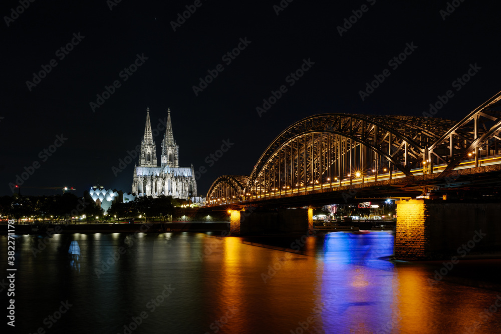 Night scenery of Köln' old town, and riverside of Rhein River, with background of Cologne Cathedral and Hohenzollern Bridge in Cologne, Germany.