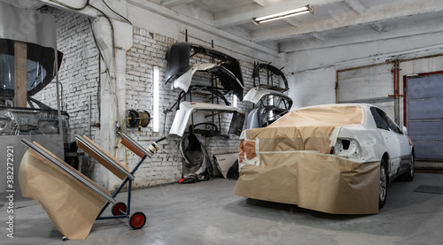 Car with paper cover parked in garage photo