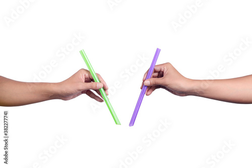 Two hands holding big drinking green and purple straws isolated on white background.