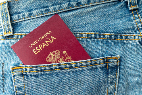 CLOSE UP OF SPANISH PASSPORT IN BLUE JEANS POCKET. TRAVELER CONCEPT. 