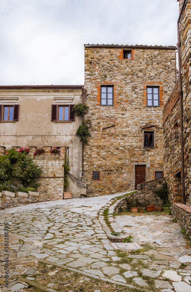 PANZANO IN CHIANTI, ITALY - OCTOBER 10, 2018: Street with winding cobbled road and medieval houses in Panzano in Chianti, Tuscany, Italy PANZANO IN CHIANTI, ITALY - OCTOBER 10, 2018: Street with winding cobbled road and medieval houses in Panzano in Chianti, Tuscany, Italy