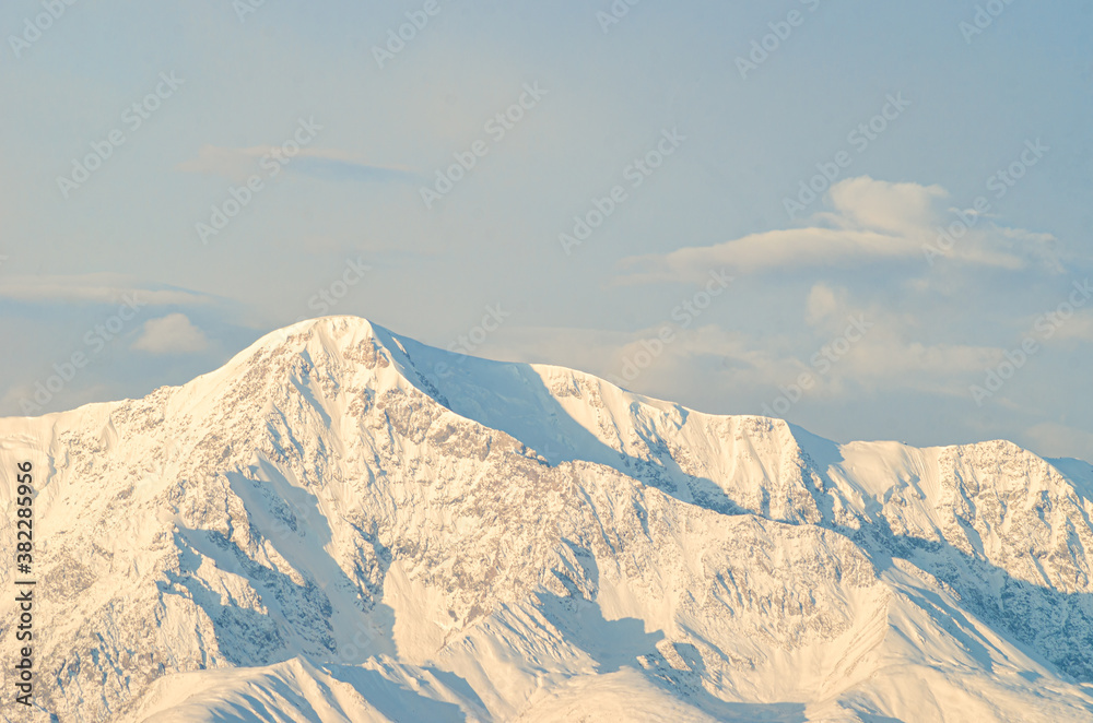 panoramic view of picturesque snowy mountains tops on blue sky background panoramic view of picturesque snowy mountains tops on blue sky background