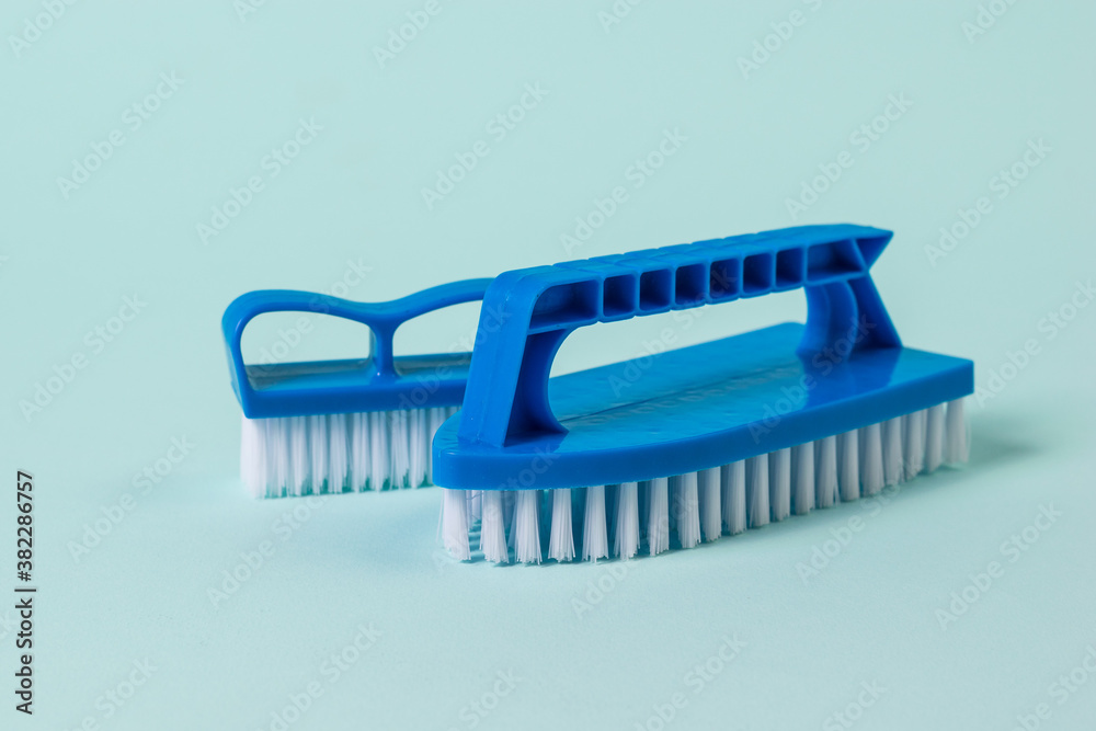 Two blue cleaning brushes on a blue background. Two blue cleaning brushes on a blue background.