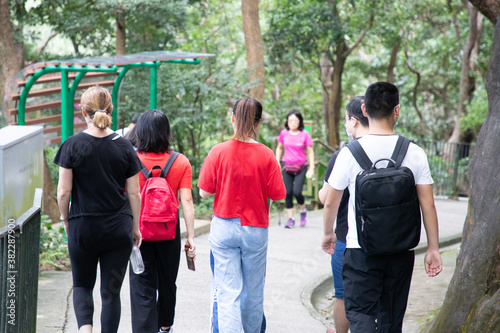 young men, women or boys and girls, university students with face masks hiking along trails in Victoria Peak, Hong Kong during covid-19