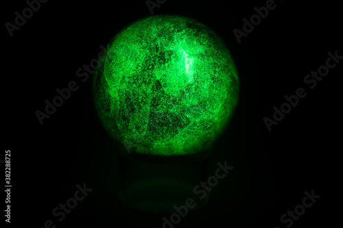 glowing green spheres fluorite on a black background looks like a planet or moon