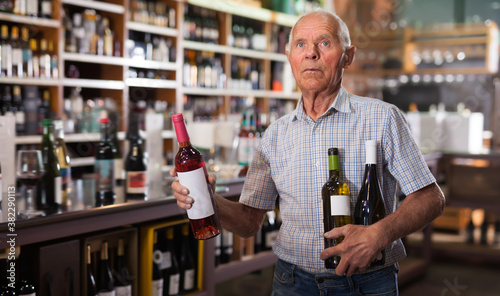 Fényképezés Serious male visiting winehouse in search of bottle of good wine