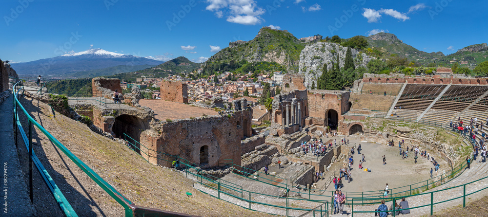 TAORMINA, ITALY - APRIL 9, 2018: The Greek Theatre with the Mt. Etna volcano and the City.