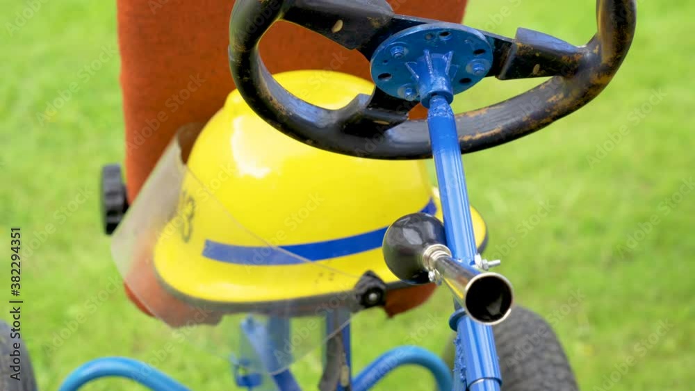 A small bicycle with the hard hat on the seat A small bicycle with the hard hat on the seat
