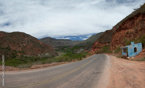 Traveling along the asphalt road high in the mountains. Panorama view of the empty highway across the hills and valley. 