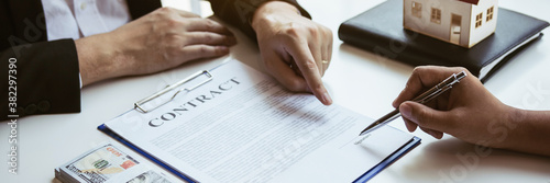 Εκτύπωση καμβά Business people home sales broker is using a pen pointing to the house model and describing the various components of the house